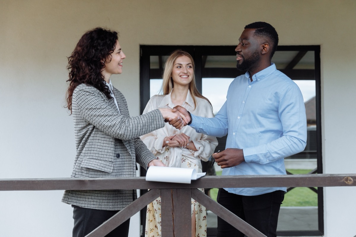 Real estate agent meeting and shaking hands with happy clients