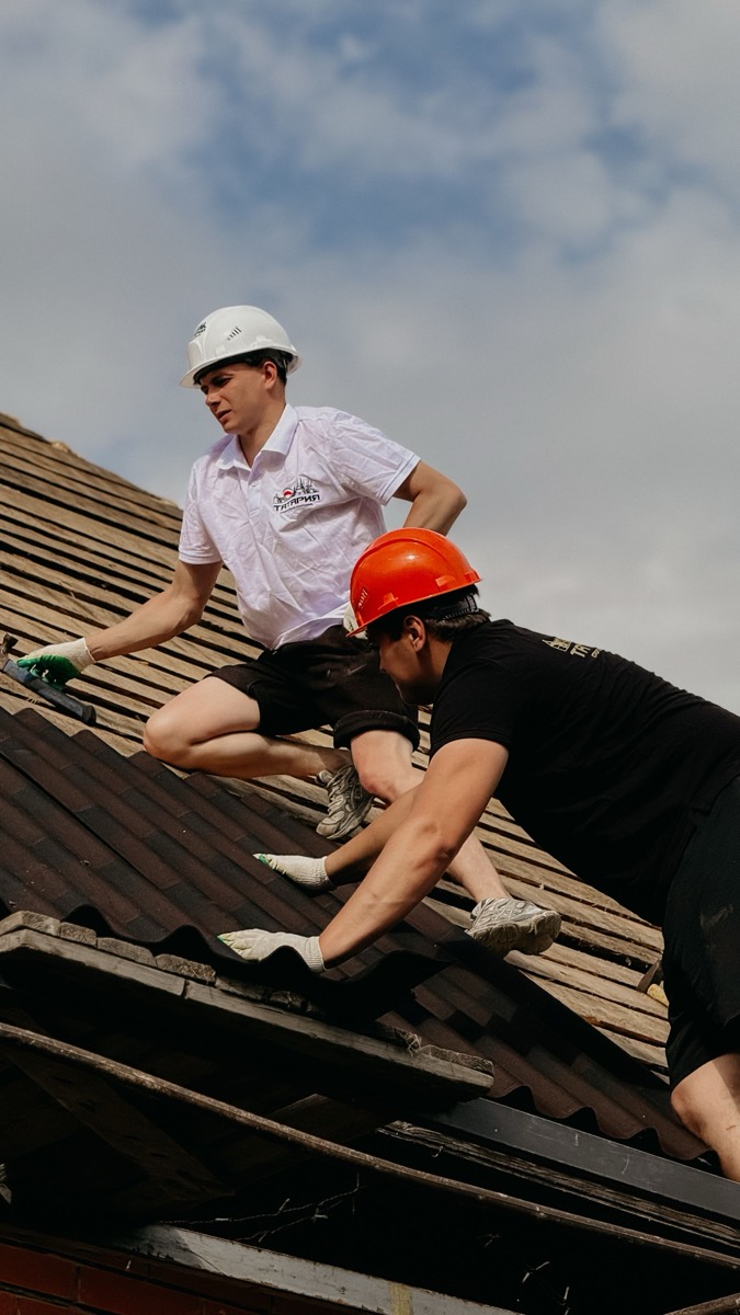 Professional roofing crew installing shingles on a residential roof