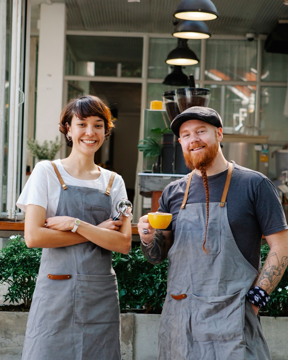 Happy Phoenix business owners, a smiling couple in aprons outside their shop